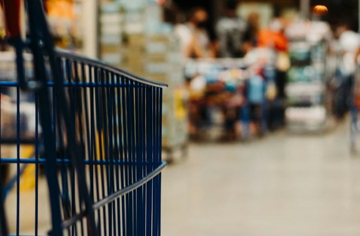 Blurred retail store aisle with a shopping cart, representing retail storefront and inventory automation